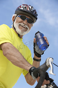 拿着水瓶的资深男性骑自行车者画象