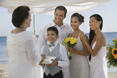 新娘和新郎与家人在海滩婚礼上