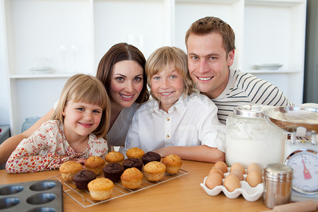 幸福的家庭展示他们的松饼