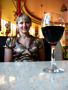 桌上的一杯红酒和一个女孩