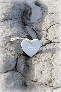 土地裂纹纹理摄影照片_沙滩上的几颗木制爱心