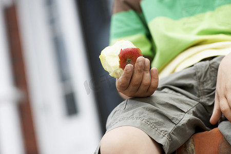 原创大气首页摄影照片_拿着一半被吃掉的苹果的小男孩的中间部分