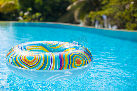 充气泳池摄影照片_蓝色泳池中的彩色泳池漂浮