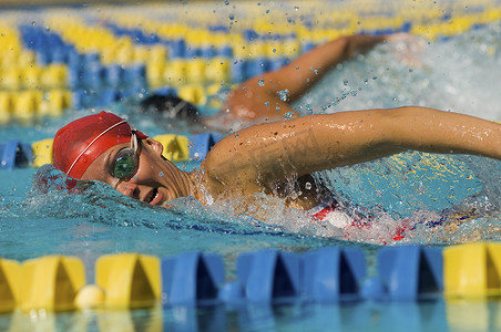 一个年轻女子在游泳池游泳的侧视图