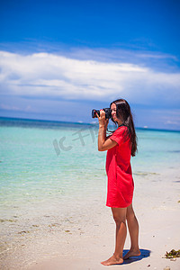 年轻漂亮女人的侧写在白色沙滩上拍摄了美丽的海景