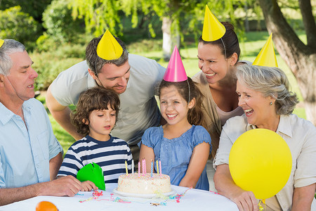 大家庭在公园的生日庆典上戴着派对帽