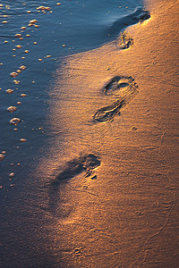 夕阳下沙滩上的脚印