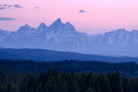 美国怀俄明州提顿县大提顿国家公园暮色中的提顿山脉和森林覆盖的山脊