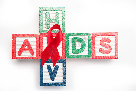 木块拼写辅助和艾滋病毒呈十字形，带有红色意识丝带