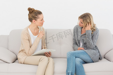 心烦意乱的女人在沙发上和她的治疗师交谈