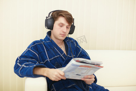 沙发上戴大耳机的男人读日记