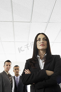 潮男背景摄影照片_办公室背景中有男同事的自信女商人