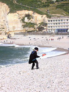 小孩在沙滩玩耍摄影照片_打扮成渔夫的小孩在沙滩上玩耍