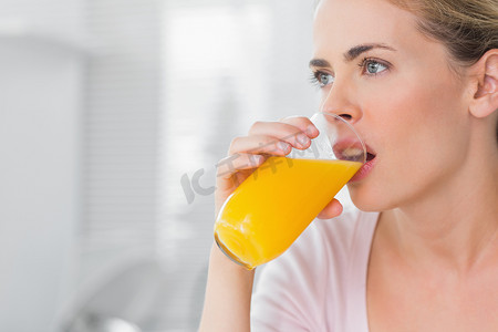 体贴的金发女人喝橙汁