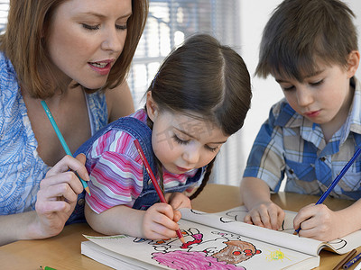 可爱的孩子涂色书，而母亲在家协助他们