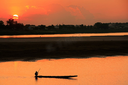 日落时在湄公河上现出轮廓的船，老挝万象