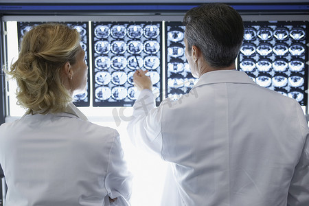 男女医生在医院讨论脑部扫描的后视图