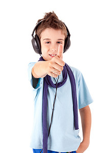 可爱的小男孩用耳机享受音乐并展示拇指