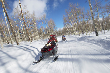 两对夫妇乘坐两辆雪地摩托沿着雪道
