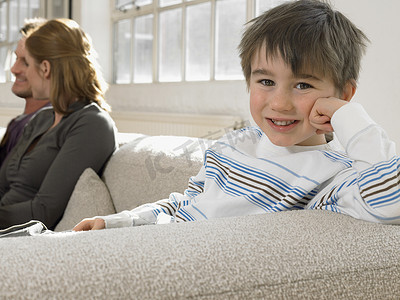 双11首页摄影照片_快乐小男孩与父母在家沙发上放松的画像