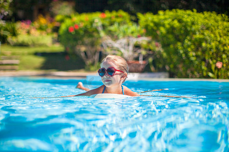 亲子游泳卡通摄影照片_小可爱快乐的女孩在游泳池里游泳