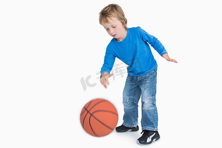 鞋子男孩摄影照片_打篮球的年轻偶然男孩
