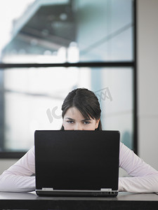 一位坐在笔记本电脑前的年轻女性的画像