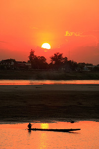 日落时在湄公河上现出轮廓的船，老挝万象