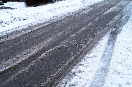 用汽车轮胎轨道和雪盖的街道