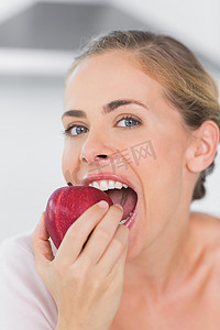 大嚼红苹果的迷人女人