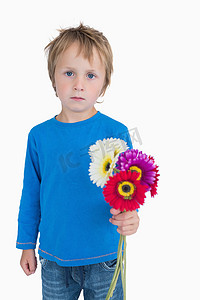拿着花的逗人喜爱的小男孩画象