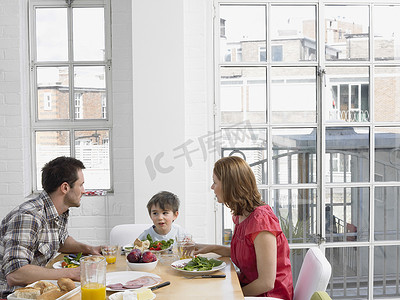 三口之家在厨房的餐桌上一起吃饭