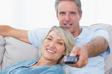 红色烫金首页摄影照片_快乐的夫妇在家放松看电视