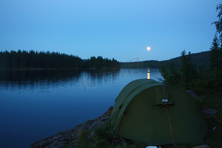 黄昏湖边摄影照片_满月时在 Nordmarka 的湖边露营。