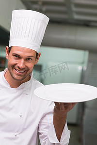 拿着盘子对着镜头微笑的厨师