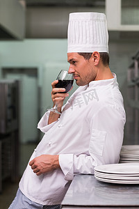 商用厨房摄影照片_厨师下班后喝杯红酒放松