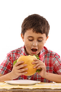 吃一个大汉堡包的男孩