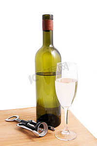 白葡萄酒瓶和带开瓶器的玻璃