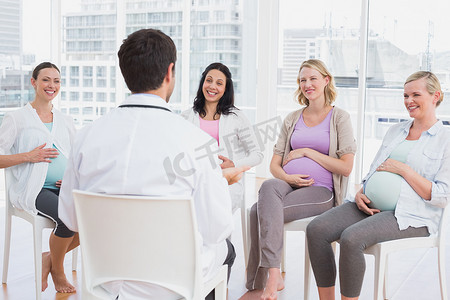 快乐的孕妇在产前课上听医生