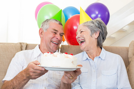 年长夫妇坐在沙发上庆祝生日