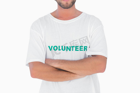 男子穿着志愿者 T 恤，双臂交叉