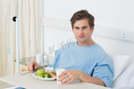 病房吃饭摄影照片_病人在病床上吃饭