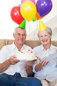 年长夫妇坐在沙发上庆祝生日