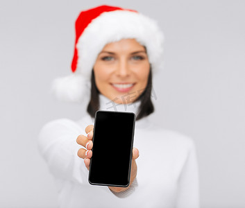 智能助手摄影照片_带着智能手机的圣诞老人助手帽微笑的女人