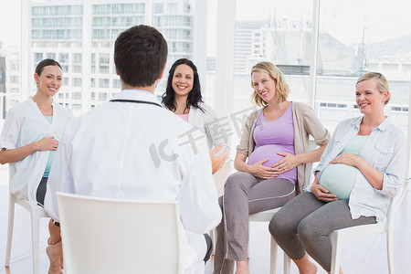 妇产科摄影照片_微笑的孕妇在产前课上听医生