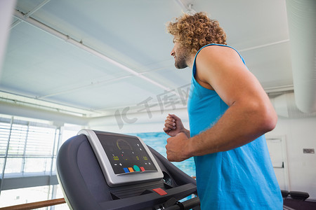 在健身房跑步机上跑步的人的侧视图
