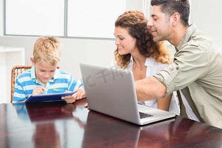 快乐的父母向儿子展示如何使用平板电脑