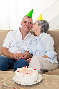 周年庆大促首页摄影照片_年长夫妇坐在沙发上庆祝生日