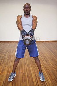 在健身房用水壶铃锻炼的肌肉男