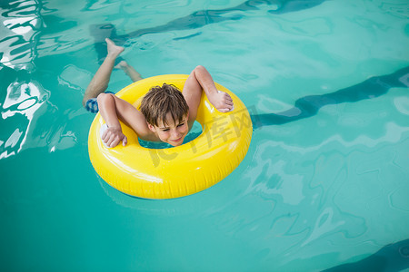 橡皮圈摄影照片_带着橡皮圈游泳的小男孩